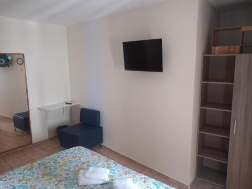 a bedroom with a bed and a tv on a wall at Sao Jose Guesthouse in Ponta Delgada