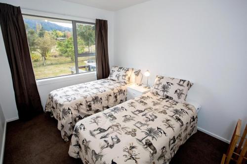a bedroom with two beds and a window at House Horse & Hound on Argelins in Hanmer Springs