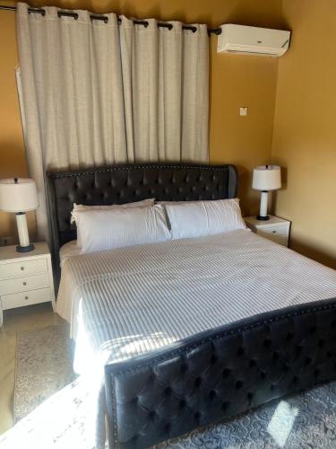 a bedroom with a large bed with two night stands at Whitehall Villa in Negril in Negril