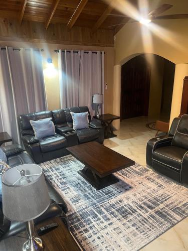 a living room with leather furniture and a table at Whitehall Villa in Negril in Negril
