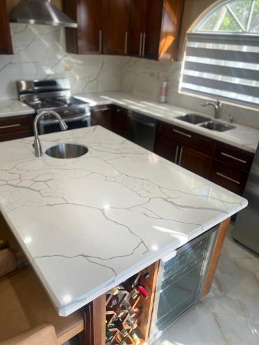 a kitchen with a sink and a counter with wine bottles at Whitehall Villa in Negril in Negril