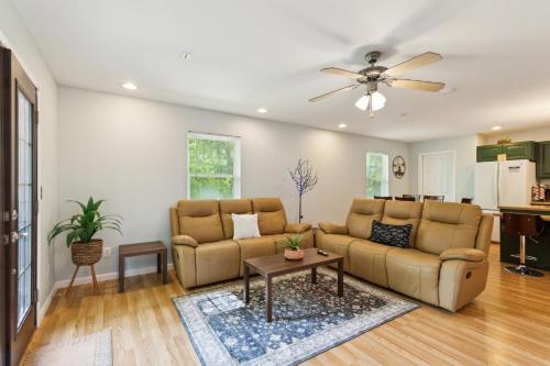 a living room with two couches and a ceiling fan at Puzzle Peak cottage in Nashville
