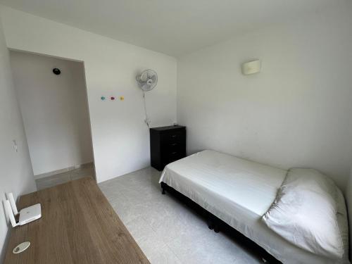 a small bedroom with a bed and a fan at Apartamento hogar para compartir con 3 habitaciones 3 piscinas, turco, sauna, gym y más en Restrepo Meta in Restrepo