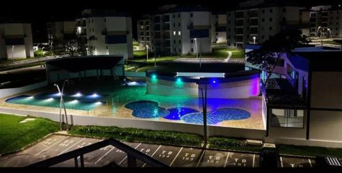 a building with a swimming pool at night at Apartamento hogar para compartir con 3 habitaciones 3 piscinas, turco, sauna, gym y más en Restrepo Meta in Restrepo