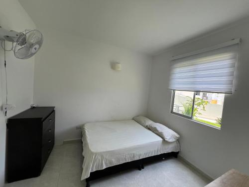 a small bedroom with a bed and a window at Apartamento hogar para compartir con 3 habitaciones 3 piscinas, turco, sauna, gym y más en Restrepo Meta in Restrepo