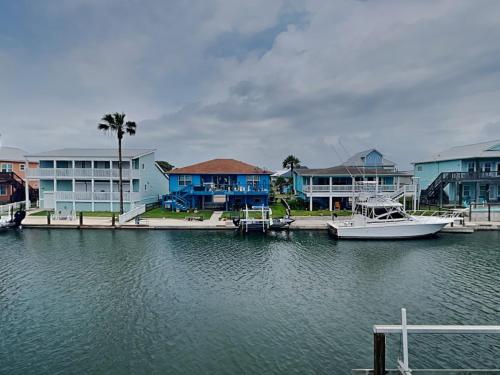a boat is docked at a dock with houses at Dolphin Paradise in Aransas Pass