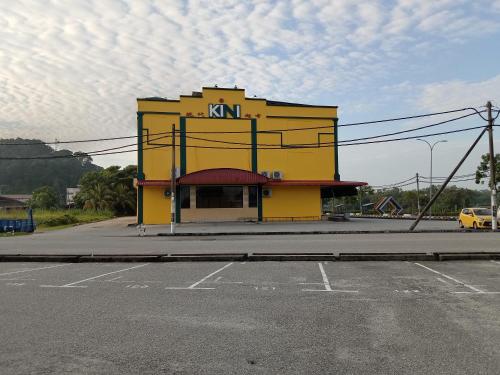 a yellow building on the corner of a street at Muallim Home in Mersing