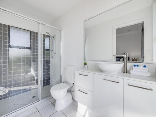 a bathroom with a toilet and a sink and a shower at Meridian Alex Beach Apartments in Alexandra Headland