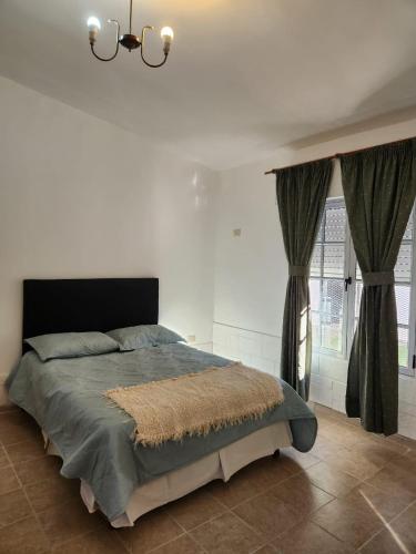 a bedroom with a large bed with curtains and a chandelier at Las Golondrinas in Santa Rosa