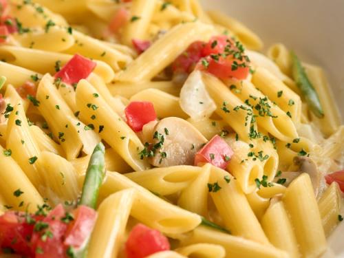 a bowl of pasta with tomatoes and parsley on it at Hotel Resol Trinity Kanazawa in Kanazawa