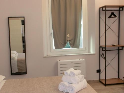 a room with a pile of towels on a bed with a mirror at Agua B'n'B in Grosseto