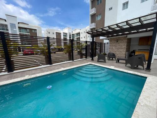 ein Schwimmbad vor einem Gebäude in der Unterkunft Modern Apt in Santiago w Pool, 3 Bedrooms, Air conditioner in Santiago de los Caballeros