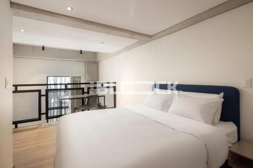 a bedroom with a large white bed with white pillows at Udara Polo - The Block in Bogotá