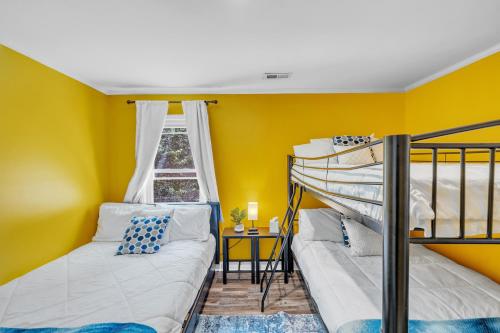 two bunk beds in a room with yellow walls at Arcade, Ping Pong, Hot Tub, Gas Grill, & King Bed in Kernersville