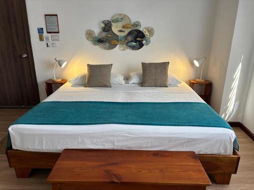 a bedroom with a large bed with a green blanket at Casa D´Cristhi in Puerto Baquerizo Moreno