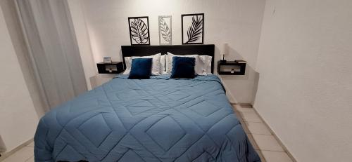 a bedroom with a blue bed with two blue pillows at Casa en Puesta del Sol/Excelente Ubicación/2 Hab/Wifi/Netflix/Super comoda in Mérida