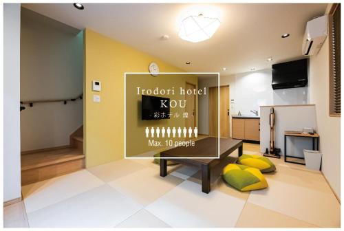 a living room with a table and yellow pillows at Irodori Hotel KOU in Fukuoka