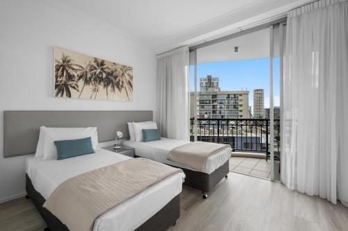 une chambre d'hôtel avec deux lits et un balcon dans l'établissement Towers of Chevron - Private Apartments - Hosted by Coastal Letting Co., à Gold Coast