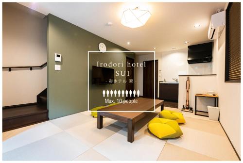 a living room with a table and yellow cushions at Irodori Hotel SUI in Fukuoka