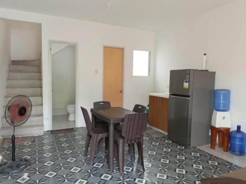 a room with a table and chairs and a refrigerator at Townhouse in Compostela Cebu in Compostela