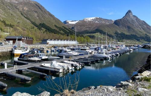 a bunch of boats docked in a harbor with mountains at Nice Home In Ørsta With Sauna in Ørsta