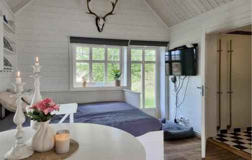 a bedroom with a bed and a table and a tv at Amazing Home In Grästorp With Sauna in Grästorp