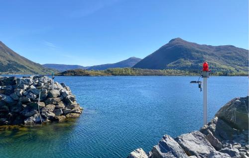 a red fire hydrant on the side of a lake at Awesome Home In Ørsta in Ørsta
