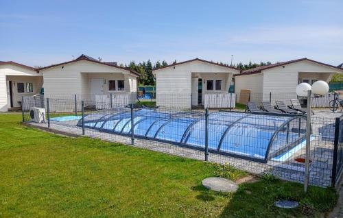 a swimming pool in a yard with some houses at Beautiful Home In Przewloka in Przewłoka