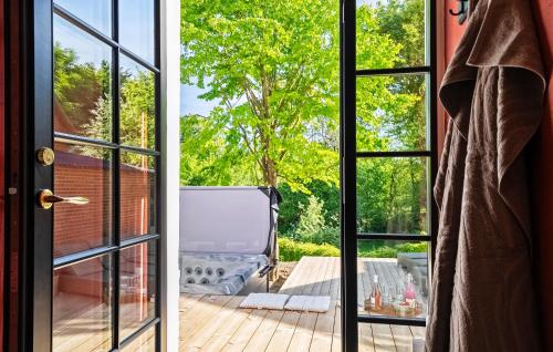 LunderskovにあるLovely Home In Lunderskov With Wifiの木の景色を望むパティオへ続く開放的なドア