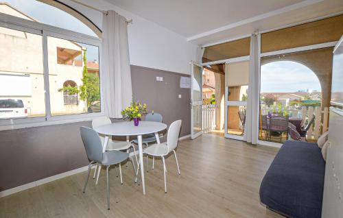 une salle à manger avec une table et des chaises et une grande fenêtre dans l'établissement Appartement Residence Piscine, à Prunete