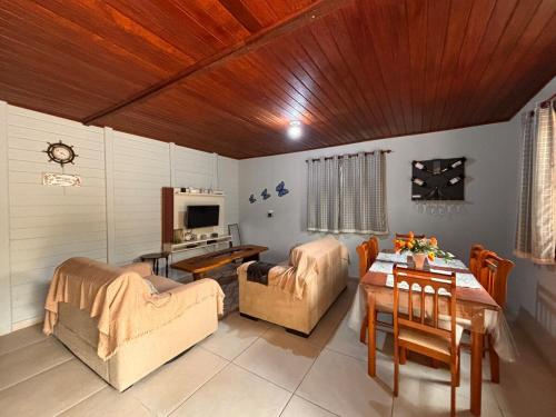 a living room with a table and a dining room at Casa Mundo Buzios in Buzios