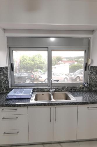 a kitchen with a sink and a window at Sunset Bay Deluxe Villa in Ksamil