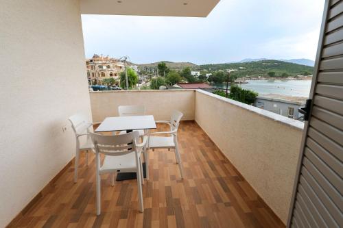 a balcony with a table and chairs and a view of the ocean at Sunset Bay Deluxe Villa in Ksamil
