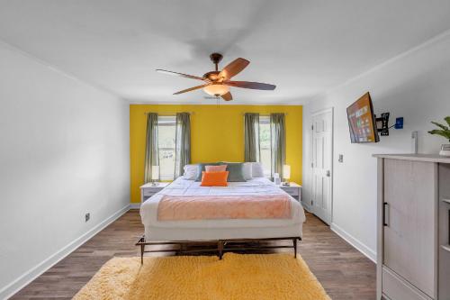 a bedroom with a bed and a ceiling fan at Firepit Games Grill Hot Tub Arcade & King Bed in Kernersville