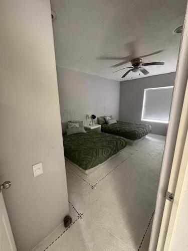 Zimmer mit 2 Betten und einem Deckenventilator in der Unterkunft Exclusivo Alojamiento en Real diamante in Acapulco