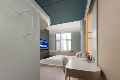 a bedroom with a bed and a table and chairs at Atour X Hotel Beijing Wangjing 798 in Beijing