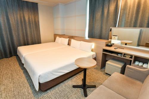 เตียงในห้องที่ Sanco Inn Nagoya Shinkansen-guchi Annex