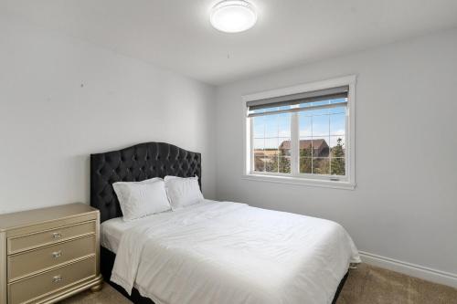 ein weißes Schlafzimmer mit einem Bett und einem Fenster in der Unterkunft Acreage, 5 bdrm, King Bed, AC, Wood Fireplace, Rural in Balzac