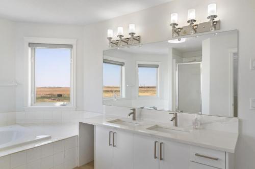 ein weißes Badezimmer mit zwei Waschbecken und einem Spiegel in der Unterkunft Acreage, 5 bdrm, King Bed, AC, Wood Fireplace, Rural in Balzac