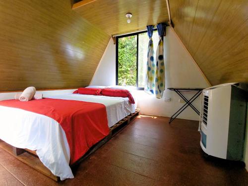 a bedroom with a bed and a tv and a window at Chalets Silencio del Bosque in Fortuna