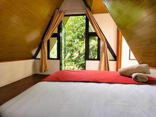 a bedroom with a large bed with a large window at Chalets Silencio del Bosque in Fortuna