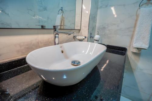a white sink in a bathroom with a mirror at Nile Crown Luxor in Luxor
