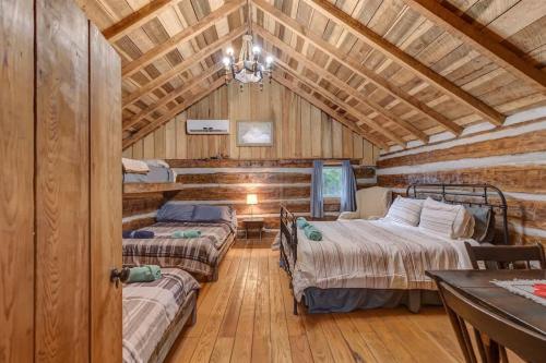 a bedroom with three beds in a log cabin at Hickory Haven Cozy Lakefront Escape & Dock in Cadiz