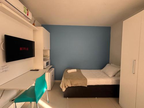 a bedroom with a bed and a desk with a monitor at Ház Jardim Guanabara in Rio de Janeiro