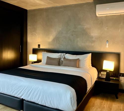 a large bed in a hotel room with two lamps at Executive Suite - Llanogrande in San Antonio de Pereira