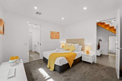 a bedroom with a bed with a yellow blanket on it at Water Front at Geelong Holiday K Villa in North Shore
