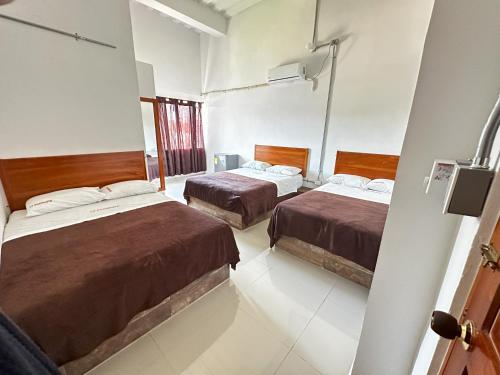 a room with two beds and a window at LA PLAZOLETA in Doradal