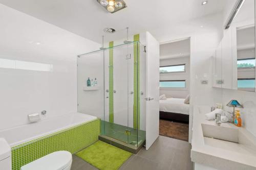 a bathroom with a shower and a toilet and a sink at Water Front at Geelong Holiday K Villa in North Shore