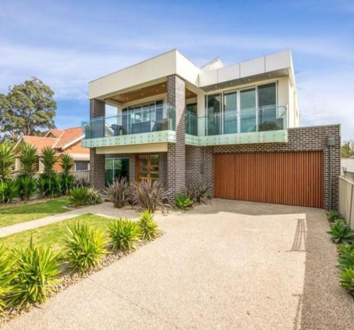 a large house with a red garage at Water Front at Geelong Holiday K Villa in North Shore