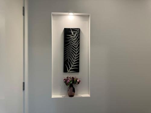 a white door with a vase with flowers in it at Water Front at Geelong Holiday K Villa in North Shore